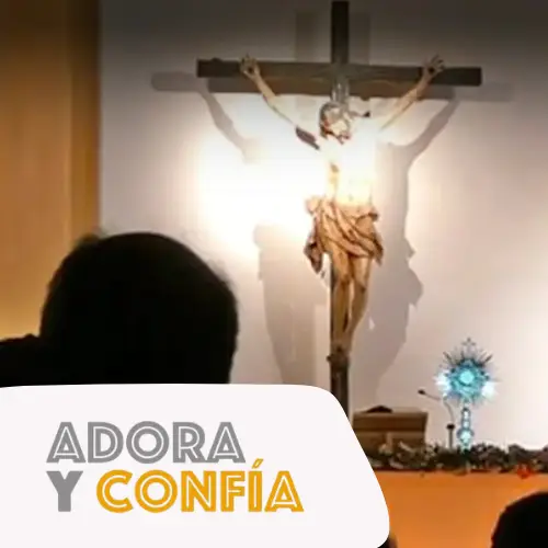 Joven adorando al Señor expuesto en la custodia junto a un crucifijo